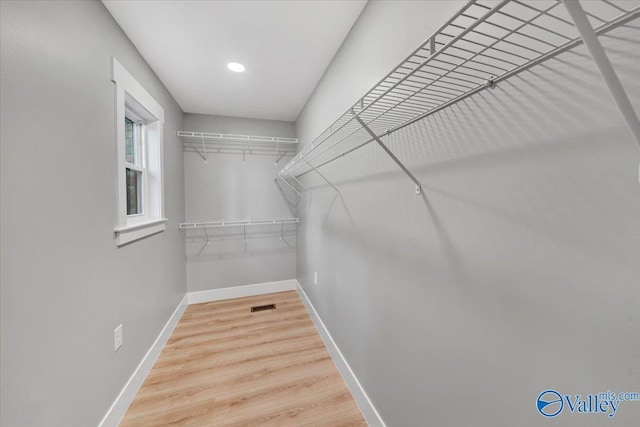 spacious closet featuring wood finished floors and visible vents