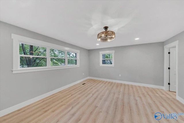 empty room with light wood-type flooring, baseboards, and recessed lighting