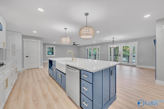 kitchen with light countertops, hanging light fixtures, white cabinetry, a sink, and dishwasher