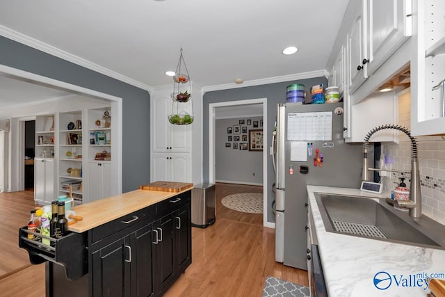 4315 Horace Dr NW, Huntsville, AL 35816 - kitchen with white cabinetry, sink, light hardwood / wood-style flooring, crown molding, and decorative backsplash