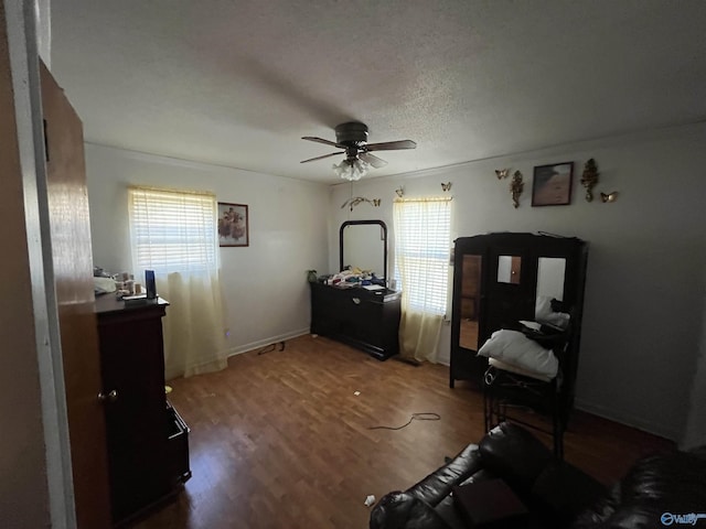 sitting room with a ceiling fan, wood finished floors, a wealth of natural light, and a textured ceiling