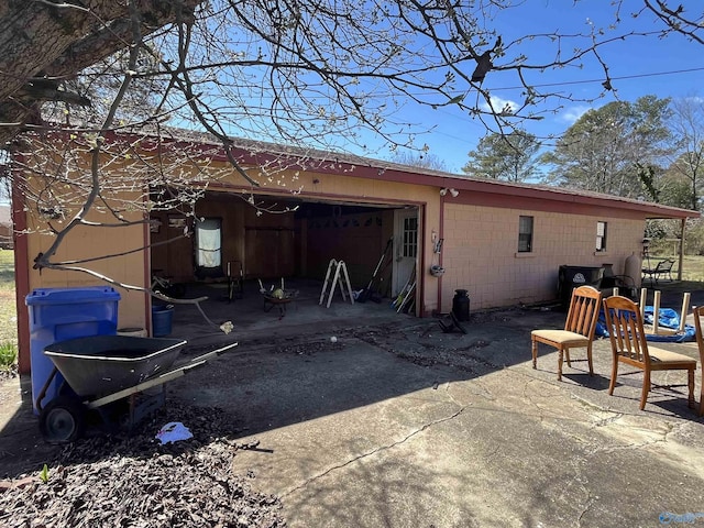 exterior space featuring an outbuilding, concrete block siding, and water heater