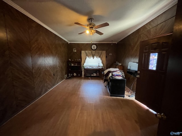 unfurnished bedroom with crown molding, a ceiling fan, and wood finished floors