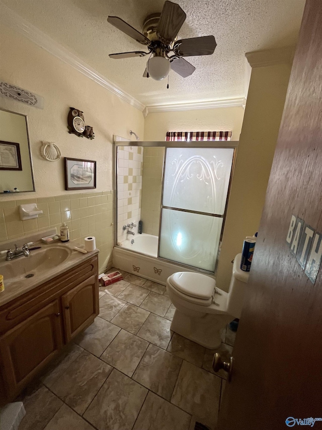 full bath with shower / bath combination with glass door, a textured ceiling, tile walls, and ornamental molding