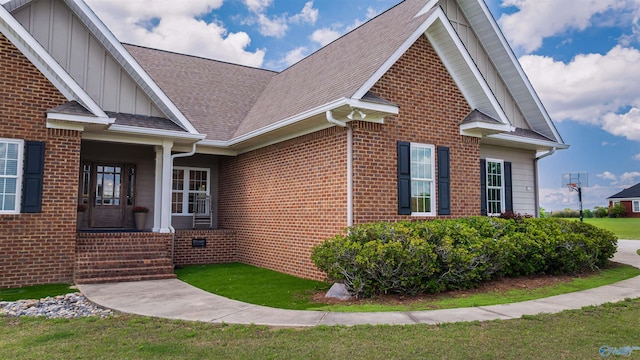 1635 County Road 47, Fyffe, AL 35971 - view of home's exterior featuring board and batten siding, brick siding, a shingled roof, a yard, and covered porch