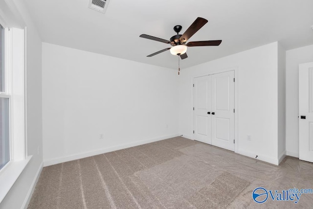 carpeted spare room featuring ceiling fan