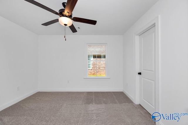 carpeted spare room featuring ceiling fan