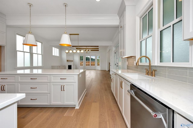 kitchen featuring pendant lighting, dishwasher, sink, light wood-type flooring, and beam ceiling