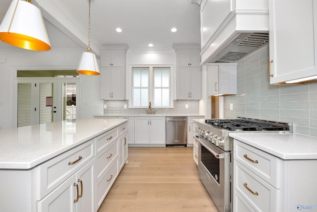 kitchen featuring white cabinets, decorative light fixtures, a wealth of natural light, and appliances with stainless steel finishes