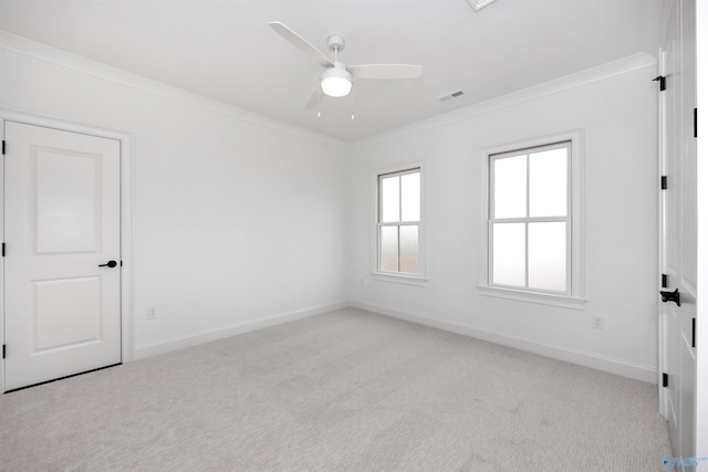 unfurnished room featuring ceiling fan, light colored carpet, and ornamental molding