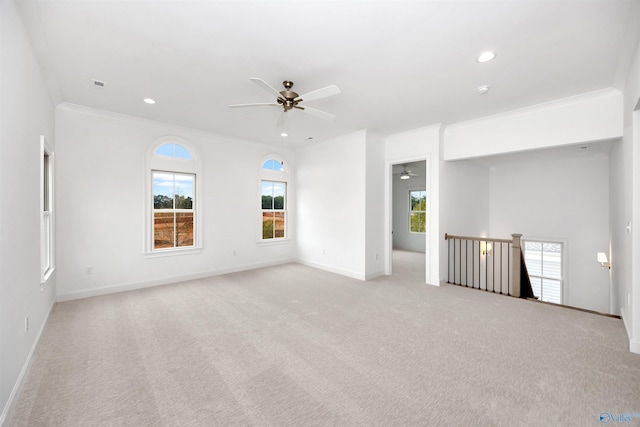 empty room featuring ceiling fan, crown molding, and light carpet