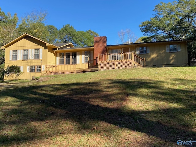 rear view of property featuring a lawn, crawl space, and a wooden deck