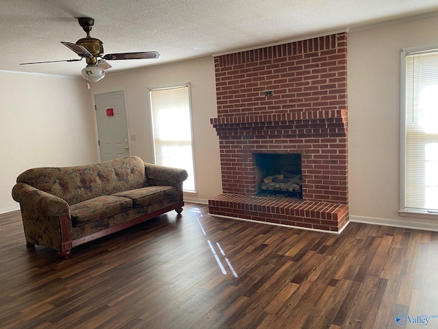 living room with a textured ceiling, dark hardwood / wood-style floors, and a healthy amount of sunlight