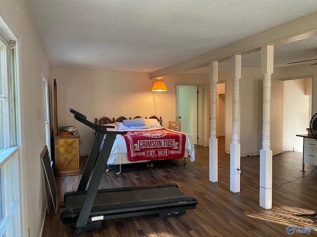 workout room featuring a textured ceiling and wood finished floors
