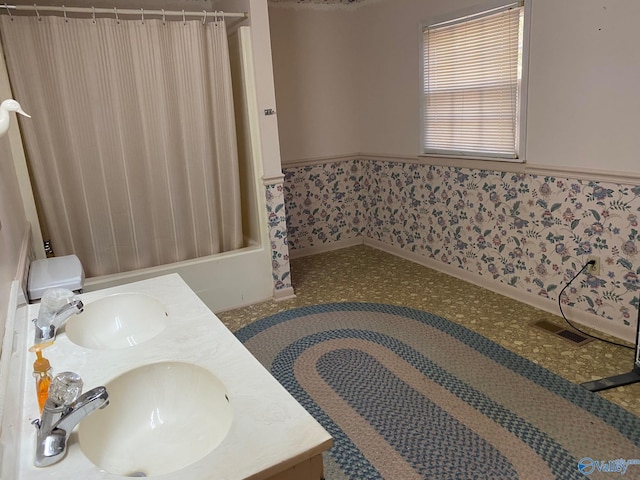 full bathroom featuring double vanity, visible vents, shower / bath combination with curtain, and a sink