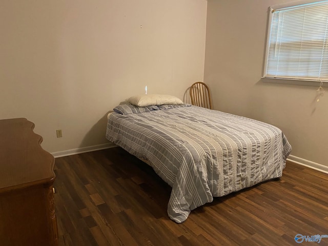 bedroom with dark hardwood / wood-style floors