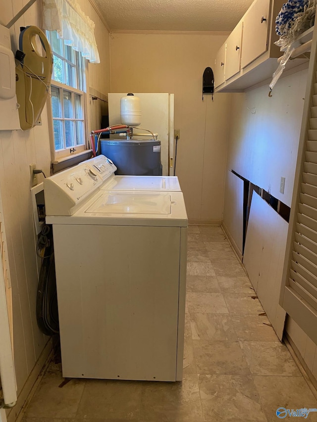 washroom with water heater, ornamental molding, washer / dryer, and cabinet space