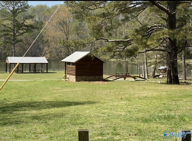 view of yard featuring an outbuilding, a water view, and a storage unit
