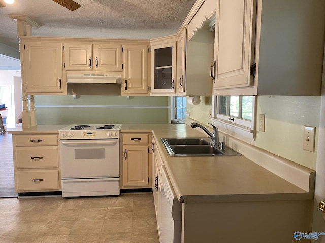 kitchen with light countertops, a sink, under cabinet range hood, and white appliances