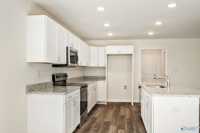 kitchen featuring a sink, dark wood finished floors, white cabinetry, stainless steel appliances, and light stone countertops