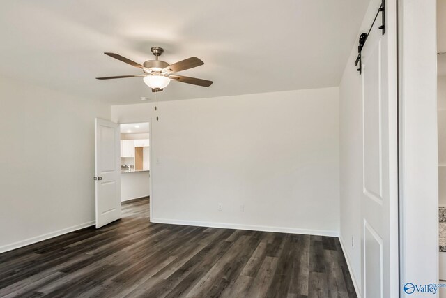 spare room with dark wood-style floors, baseboards, and ceiling fan