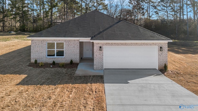 view of front facade with a front lawn, roof with shingles, concrete driveway, an attached garage, and brick siding