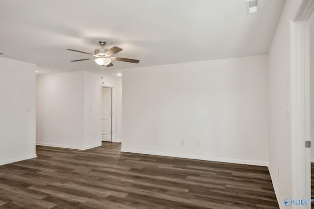 unfurnished room featuring dark wood finished floors, baseboards, visible vents, and a ceiling fan