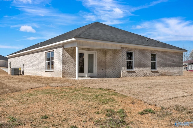 back of house featuring french doors, brick siding, and central AC