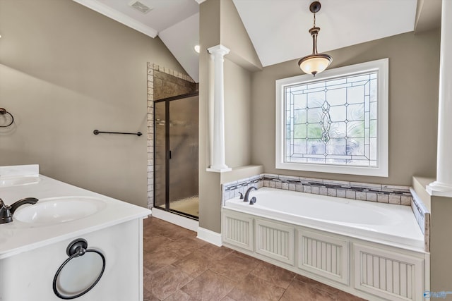 bathroom with decorative columns, shower with separate bathtub, and vaulted ceiling