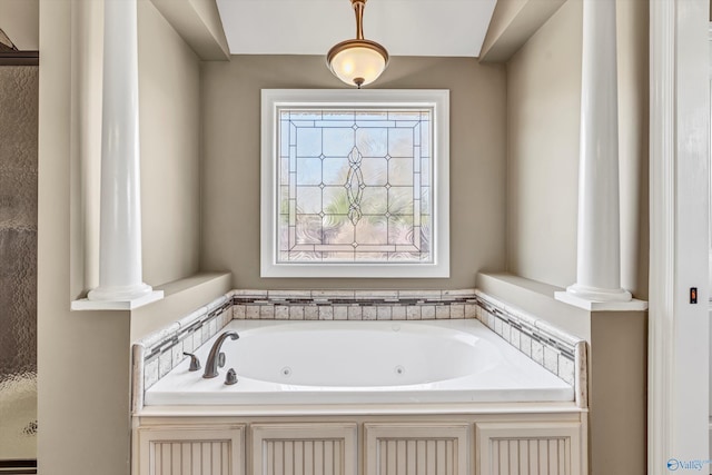 bathroom with a tub and ornate columns