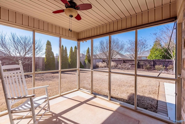 unfurnished sunroom with ceiling fan