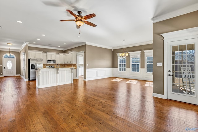 unfurnished living room with crown molding, dark hardwood / wood-style flooring, and ceiling fan with notable chandelier