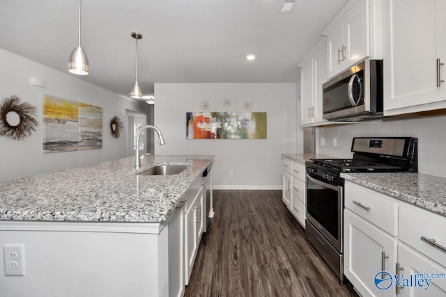 kitchen featuring white cabinetry, sink, stainless steel appliances, and a center island with sink