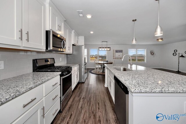 kitchen featuring sink, an island with sink, decorative backsplash, white cabinets, and appliances with stainless steel finishes