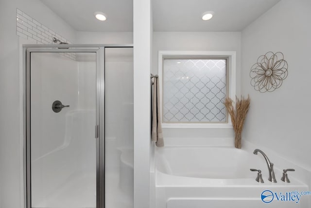 bathroom featuring independent shower and bath