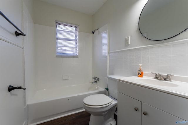 full bathroom featuring toilet, tiled shower / bath, tile walls, vanity, and hardwood / wood-style flooring