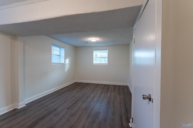 basement featuring a textured ceiling and dark hardwood / wood-style flooring