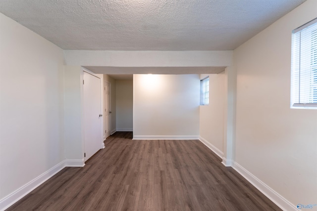 unfurnished room featuring dark hardwood / wood-style floors and a textured ceiling