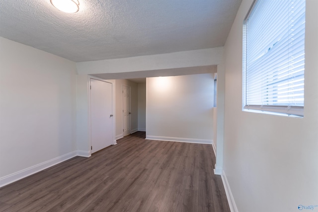 spare room with dark hardwood / wood-style flooring and a textured ceiling