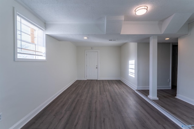 basement featuring dark hardwood / wood-style flooring and a textured ceiling