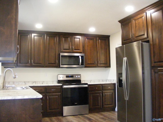 kitchen with dark wood-type flooring, dark brown cabinetry, sink, and stainless steel appliances