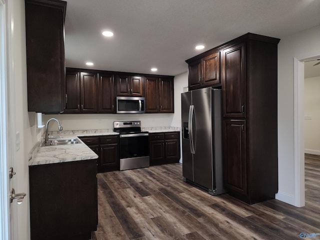 kitchen with dark brown cabinetry, sink, appliances with stainless steel finishes, and dark hardwood / wood-style flooring