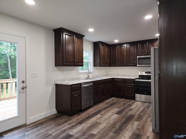 kitchen with dark brown cabinetry, sink, appliances with stainless steel finishes, and hardwood / wood-style flooring