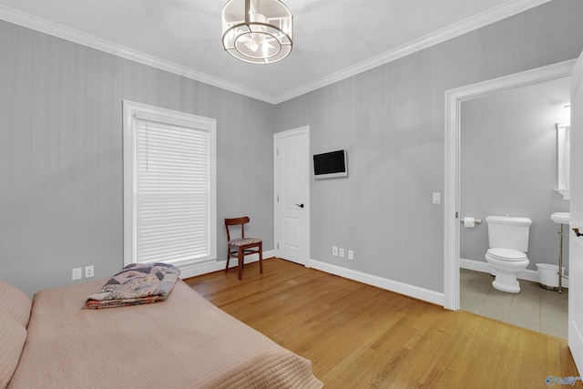 bedroom featuring light hardwood / wood-style floors, crown molding, connected bathroom, and a chandelier