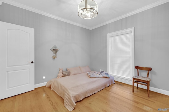 bedroom with crown molding, hardwood / wood-style floors, and an inviting chandelier