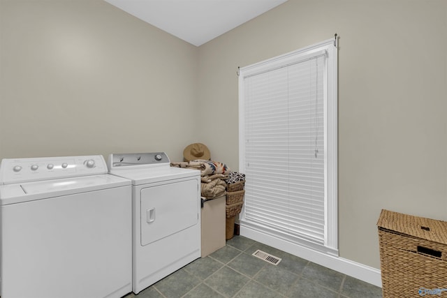 washroom featuring independent washer and dryer and dark tile patterned floors