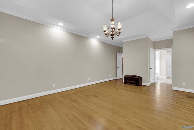 unfurnished living room featuring light hardwood / wood-style floors, crown molding, and a chandelier