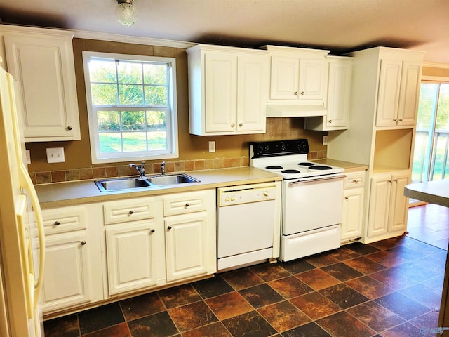 kitchen featuring white appliances, white cabinetry, a wealth of natural light, and sink