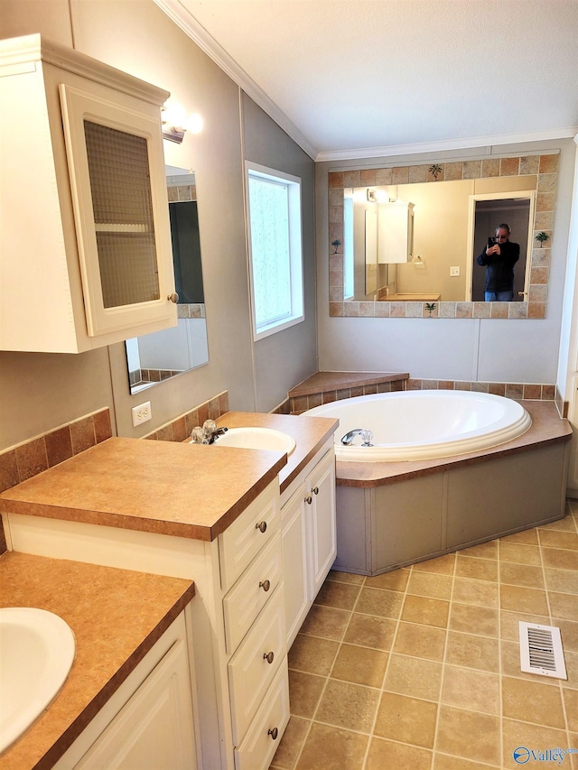 bathroom with crown molding, tile patterned flooring, vanity, and a bath