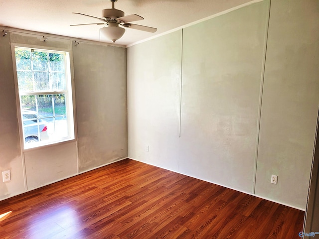 spare room featuring ceiling fan, ornamental molding, and dark wood-type flooring